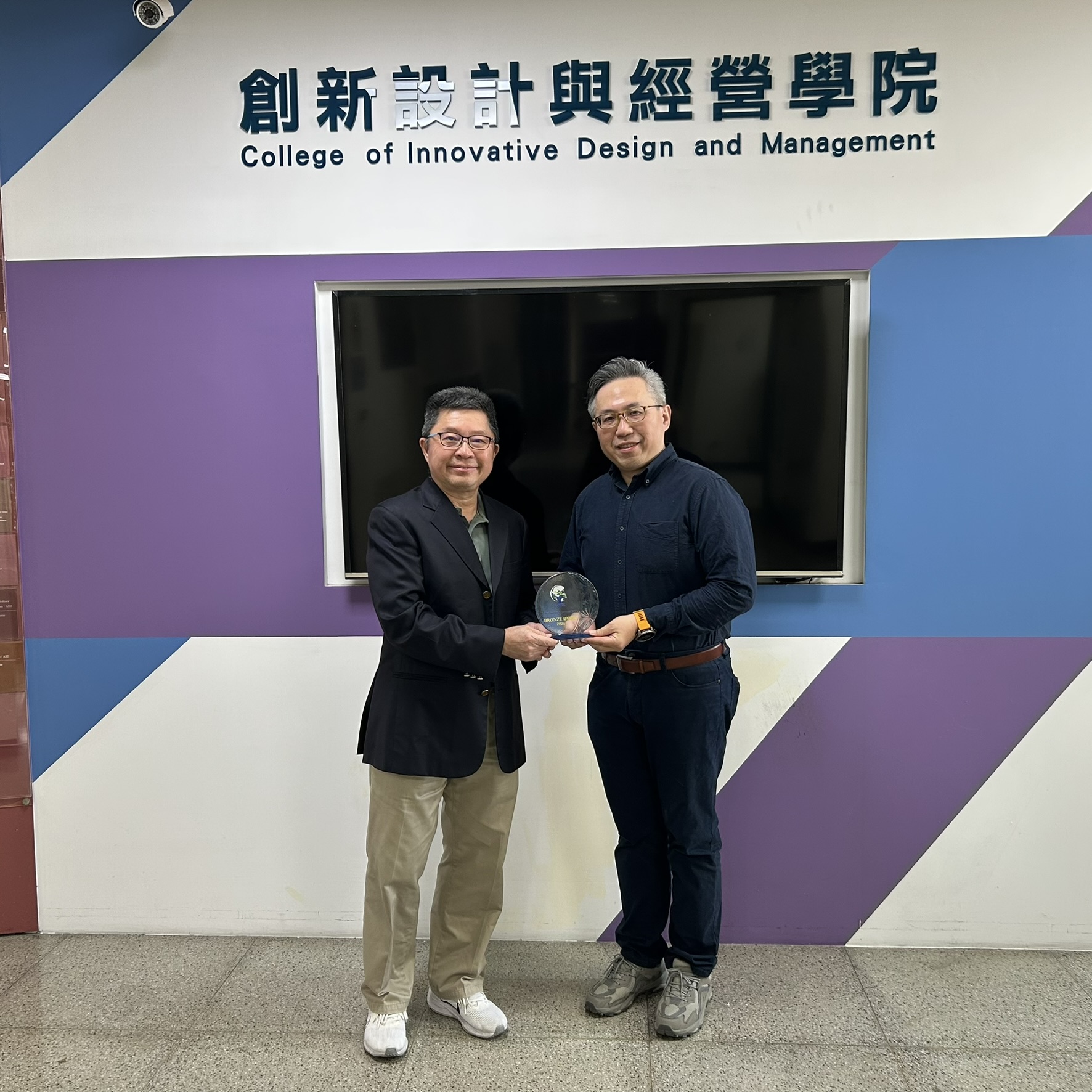 國立臺北商業大學副校長黃焜煌（左）於該校桃園校區，將 eLFA 2026 Technology Innovation Award 銅牌獎座頒予張家凱助理教授（右）